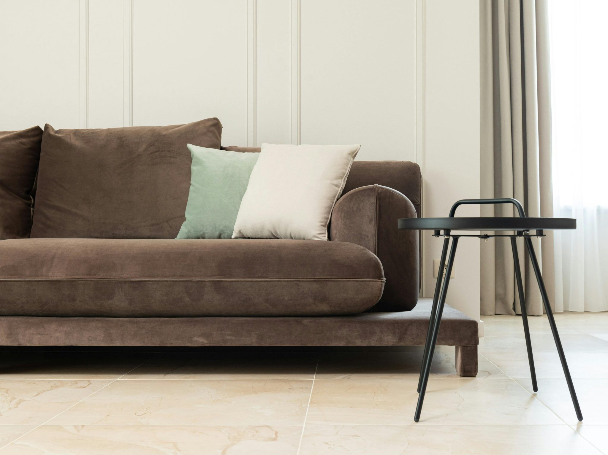brown couch with light green and cream throw pillows