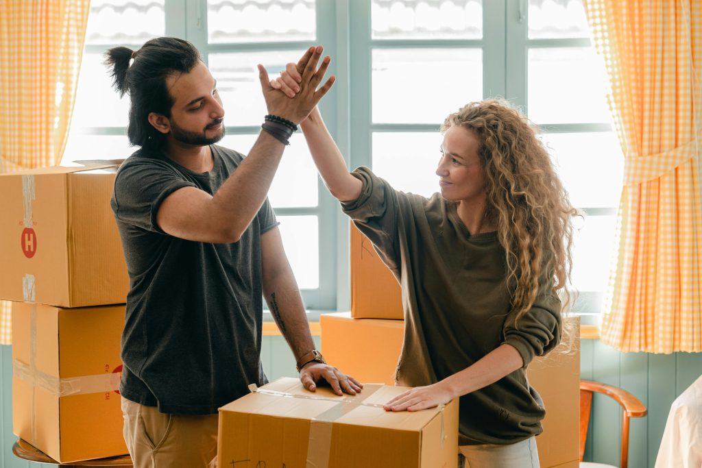 two people high-fiving over a moving box