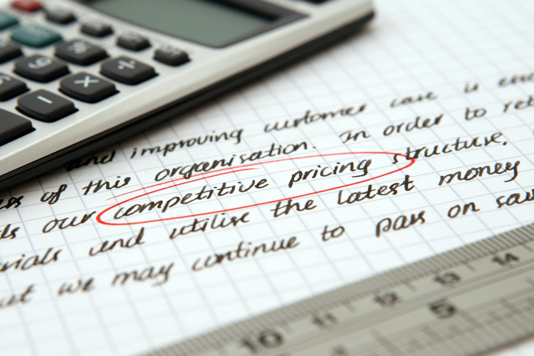 a calculator on top of a paper with the words "competitive pricing" circled in red pen