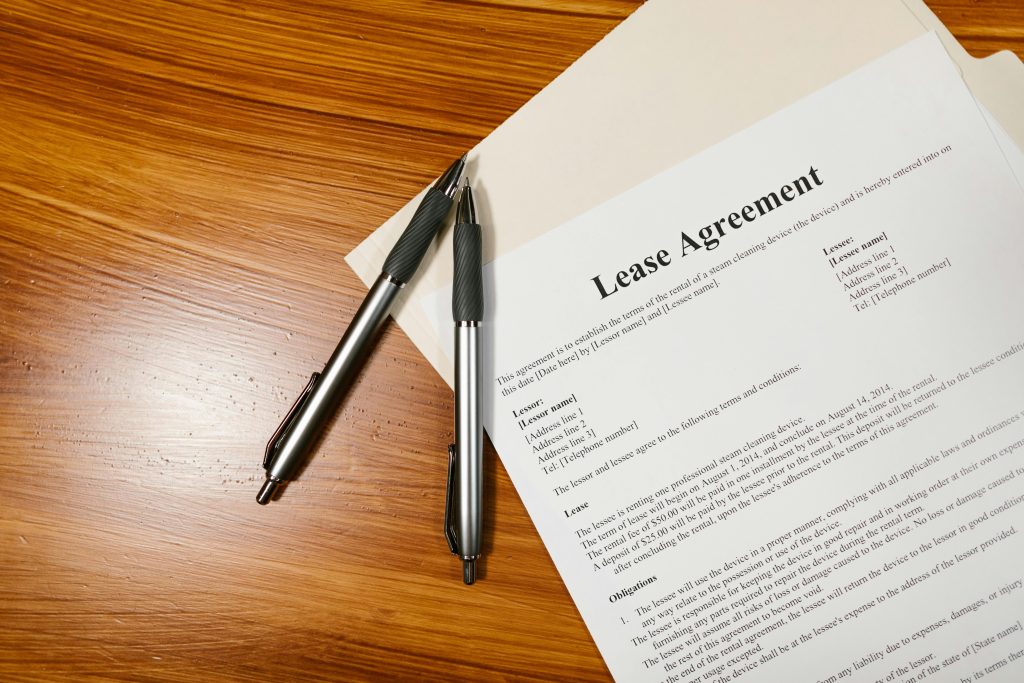 a lease agreement with two black pens on top