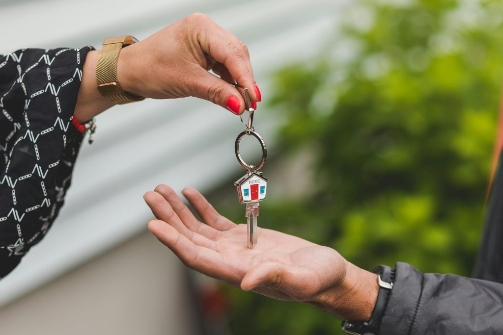 A person handing someone keys to their new home.