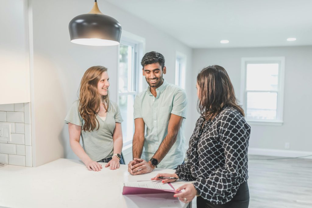 A property manager going over paperwork with a happy couple.