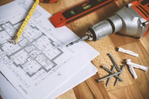 screwdriver with nails and home building plans