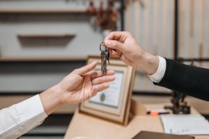 one person handing keys to another person