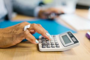 person calculating costs with calculator